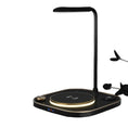 Black desk lamp with wireless charging pad on a white background